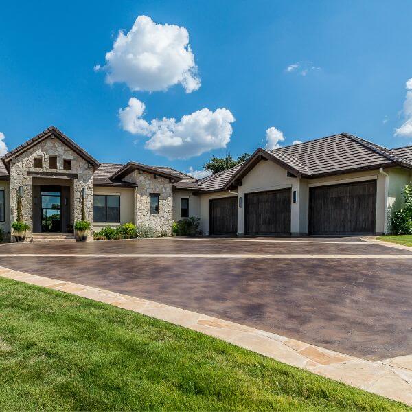 Modern home with dark epoxy driveway coating, installed by Epoxy Flooring Guys Melbourne. Clean finish with contrasting border detail.